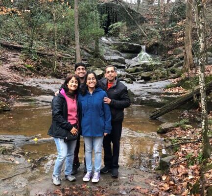 A family posing for a picture in the woods.