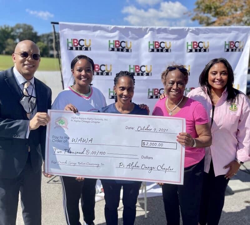 A group of people holding up a large check.