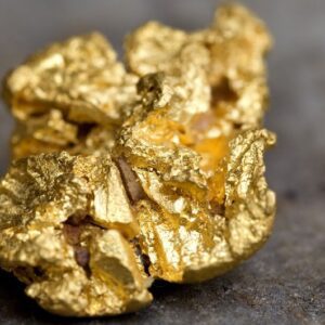 A close up of gold nuggets on the ground.