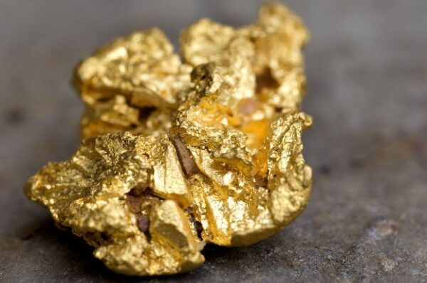 A close up of gold nuggets on the ground.