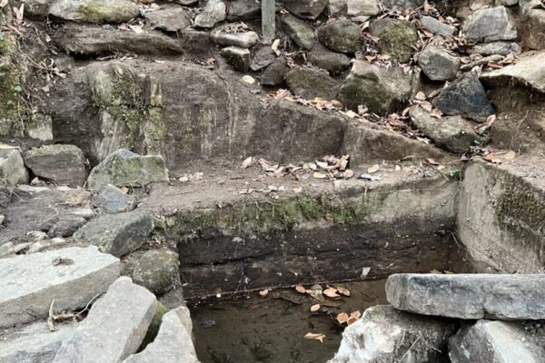 A sign that is in the middle of some rocks.