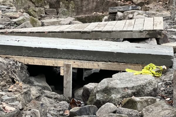 A wooden bridge is sitting in the middle of some rocks.