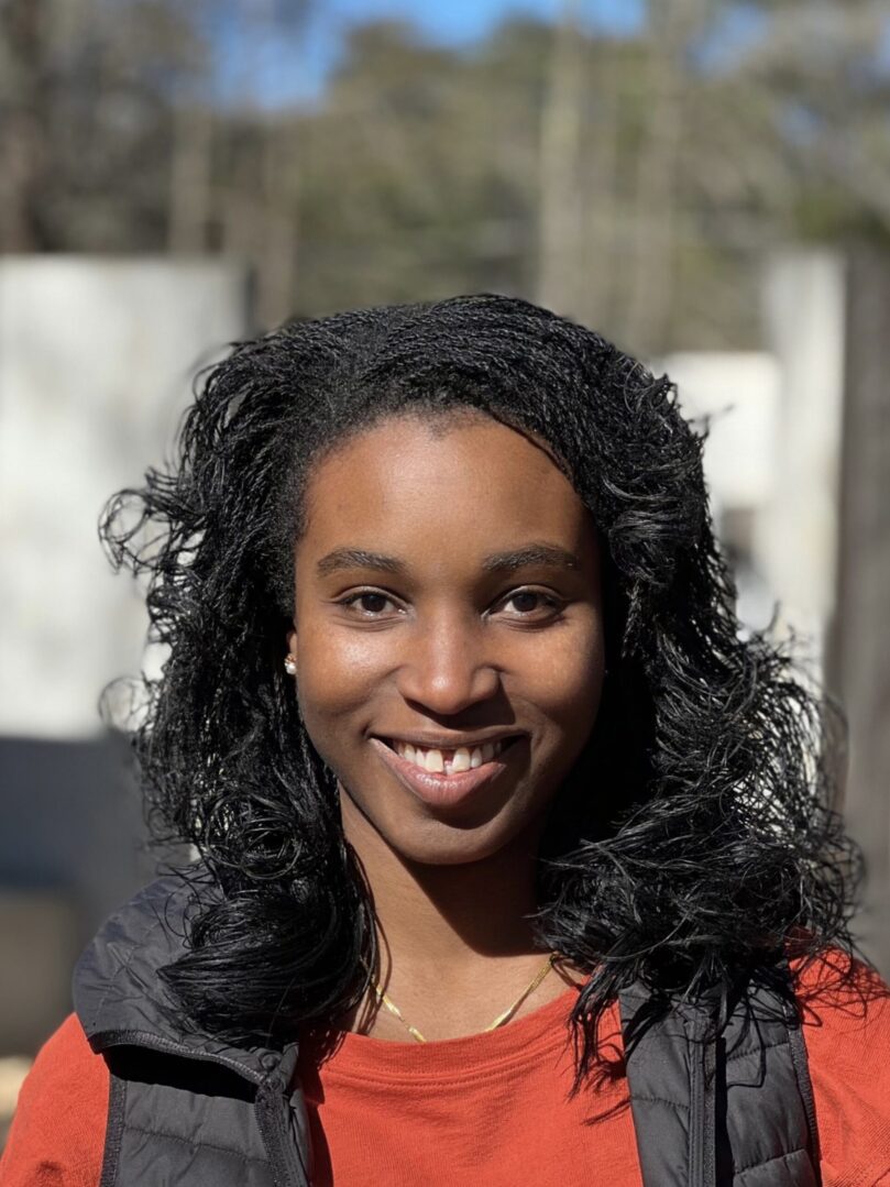 A woman with long black hair smiles for the camera.