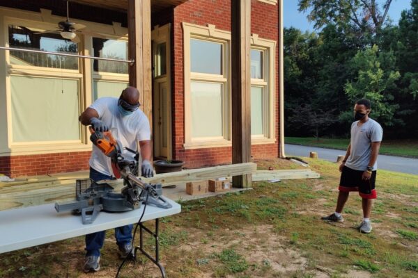 A man standing next to a table with a saw.