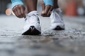 A person tying their shoes on the street.