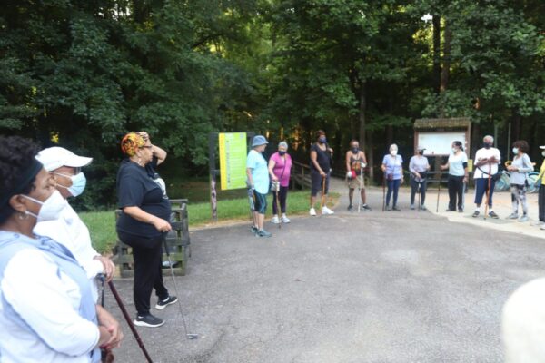 A group of people standing around in the park.