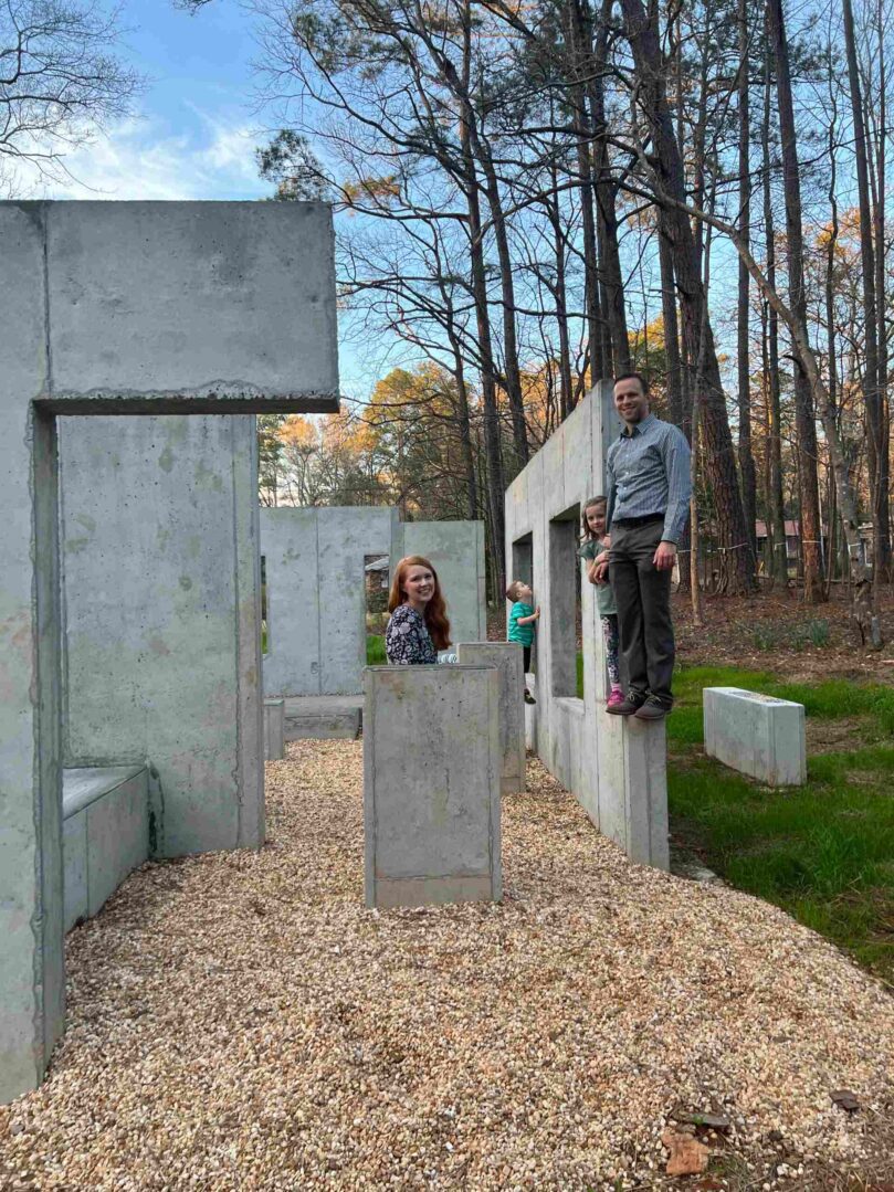 A man and woman standing in front of concrete blocks.