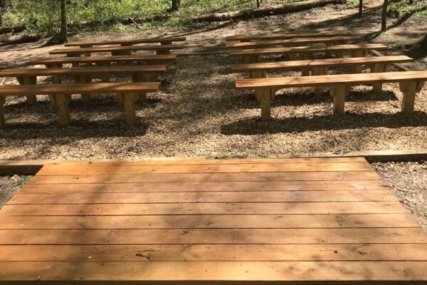 A wooden deck with benches in the middle of it