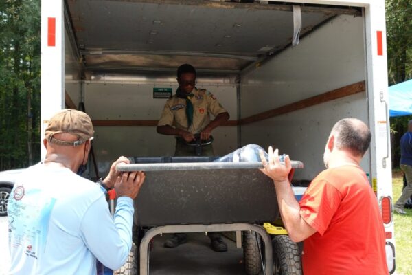 A man standing in the back of a truck.