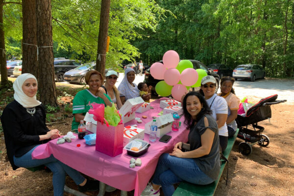 A group of people sitting at a table with balloons.