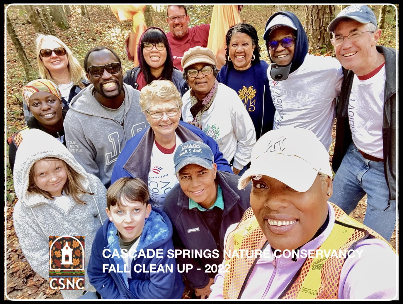 A group of people posing for a picture in the woods.