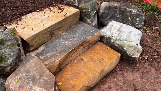 A pile of rocks and some steps on the ground.