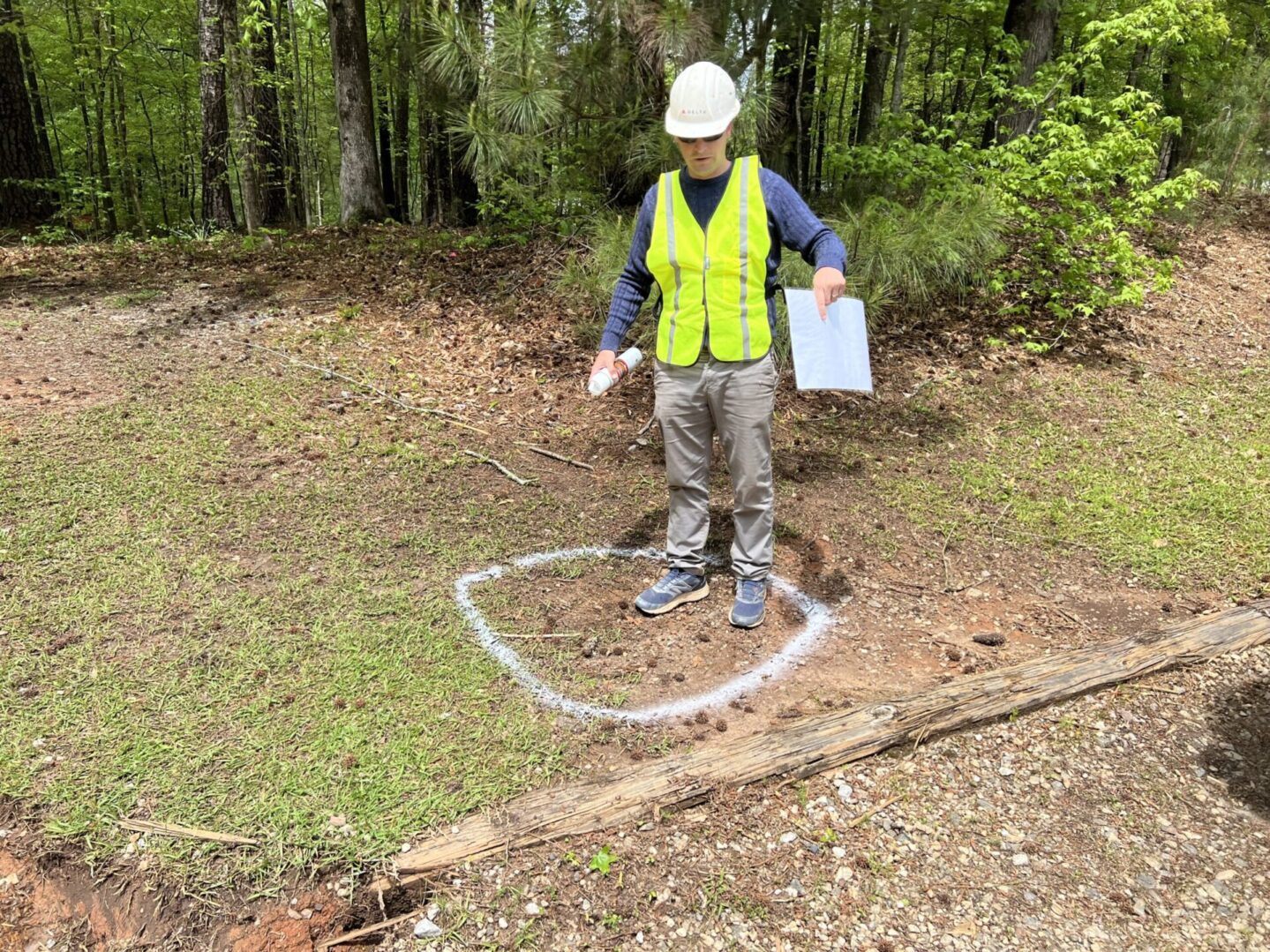 A person in a yellow vest holding a clipboard.