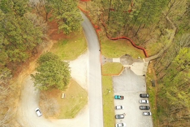 A bird 's eye view of a parking lot and trees.