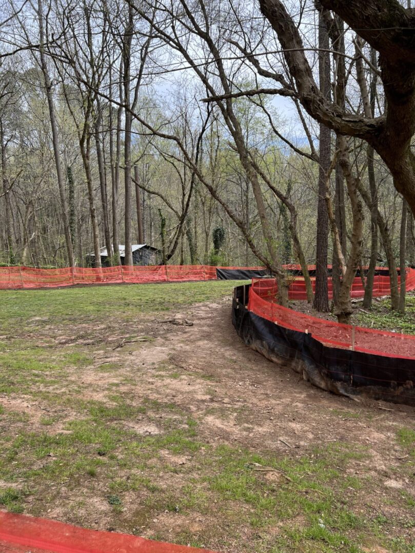 A red fence in the middle of a forest.