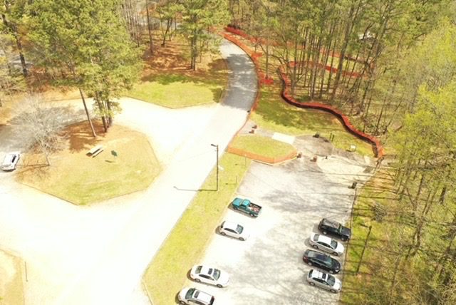 A bird 's eye view of a parking lot with cars parked on the side.