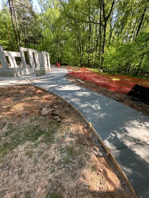 A concrete walkway in the middle of a forest.