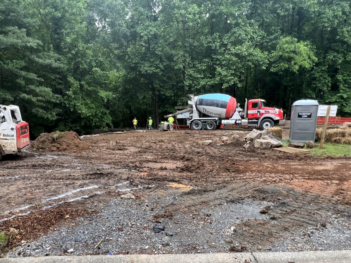 A cement truck is parked on the side of a road.