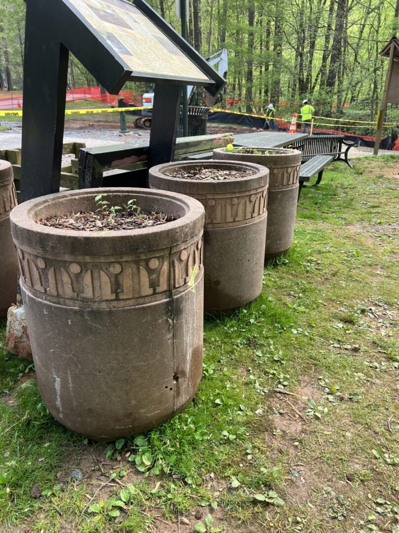 Three large concrete planters are lined up in a row.