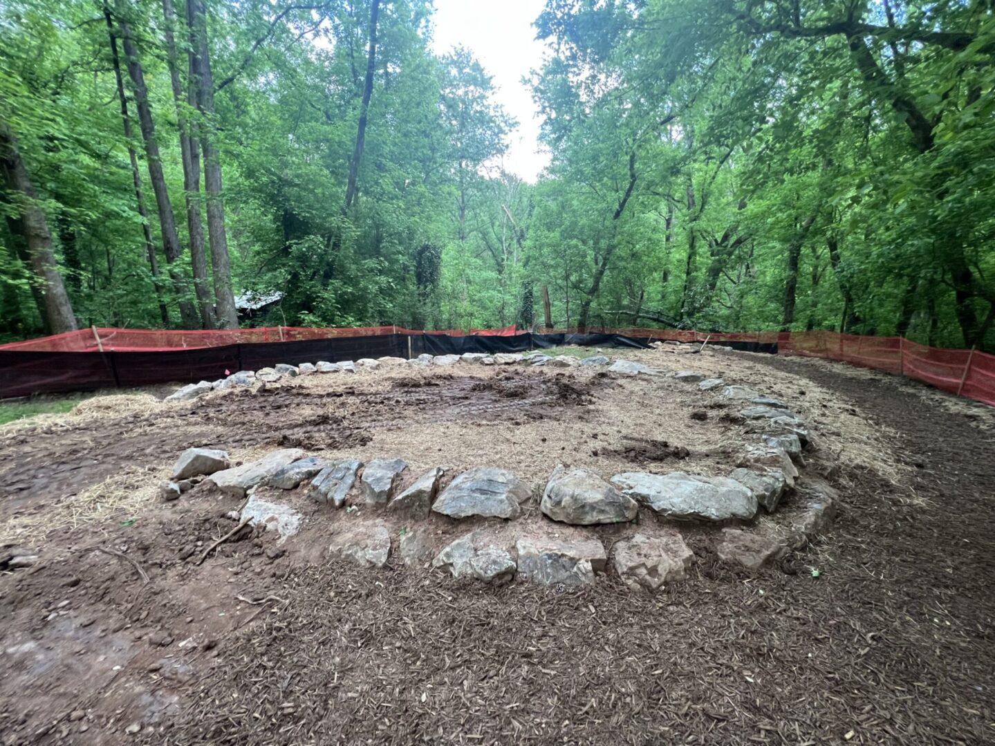 A circular stone structure in the middle of a forest.