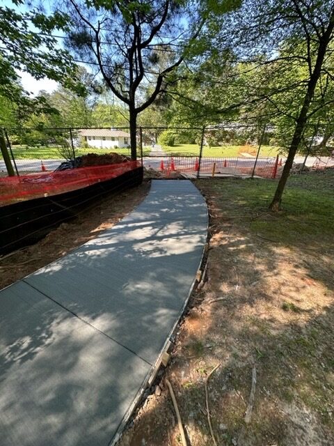 A concrete path in the middle of a park.