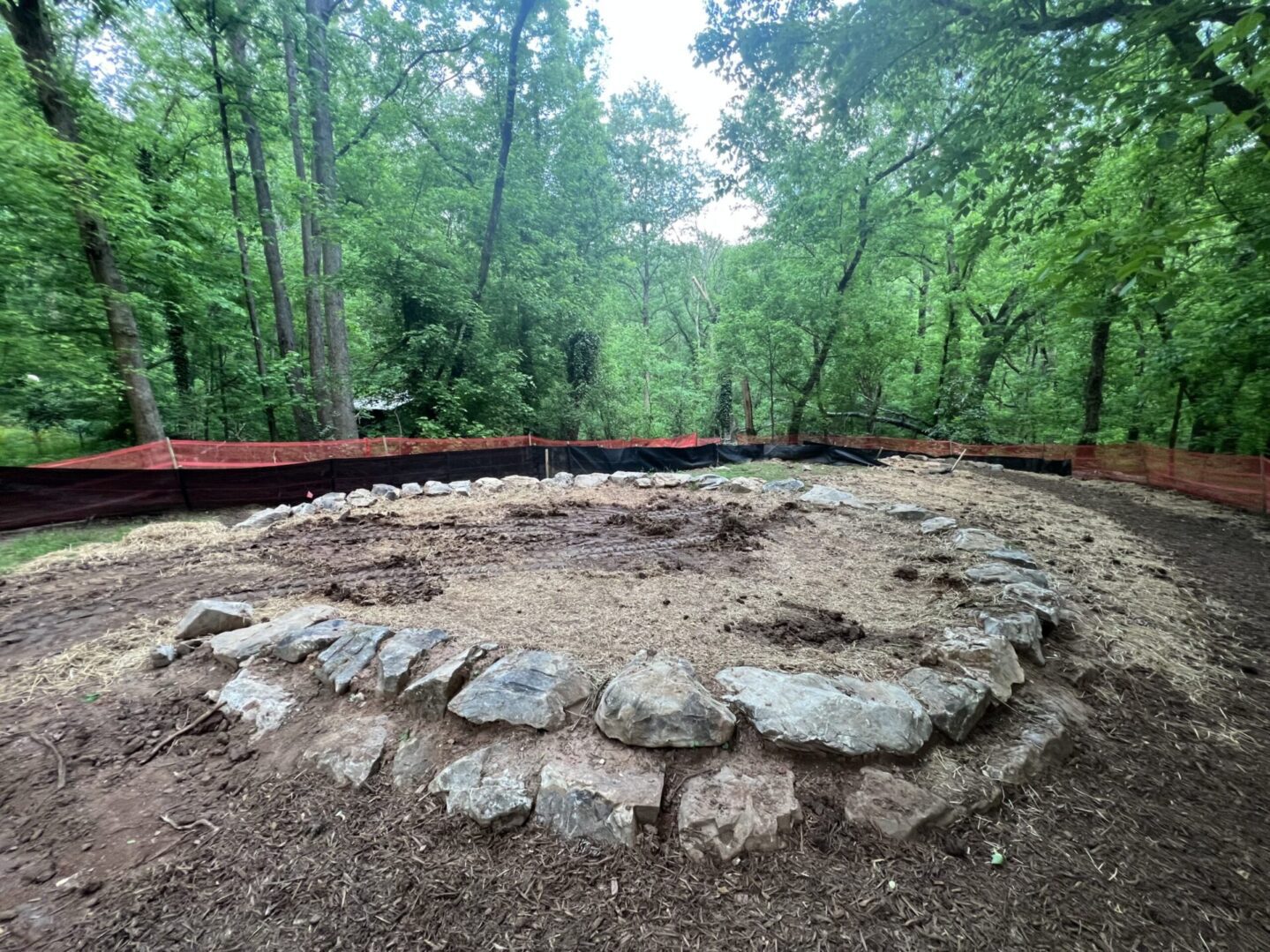 A circular stone structure in the middle of a forest.