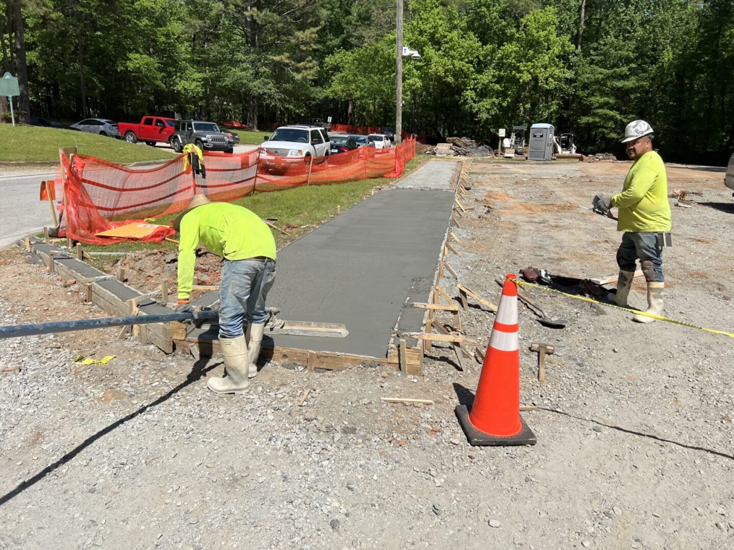 A man working on the sidewalk of a road.