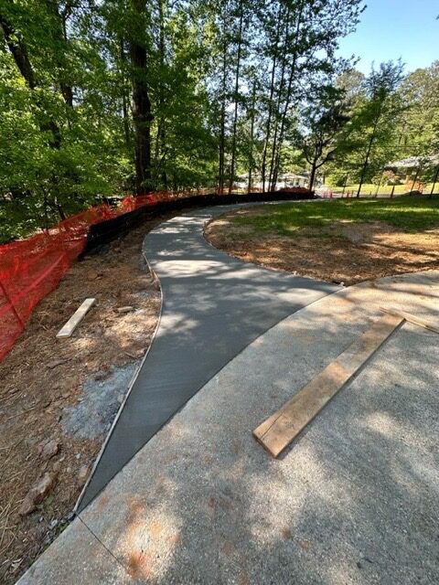 A concrete path in the middle of a park.