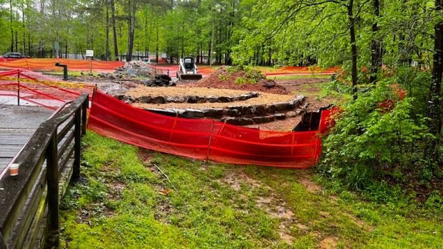 A red boat is sitting in the grass.