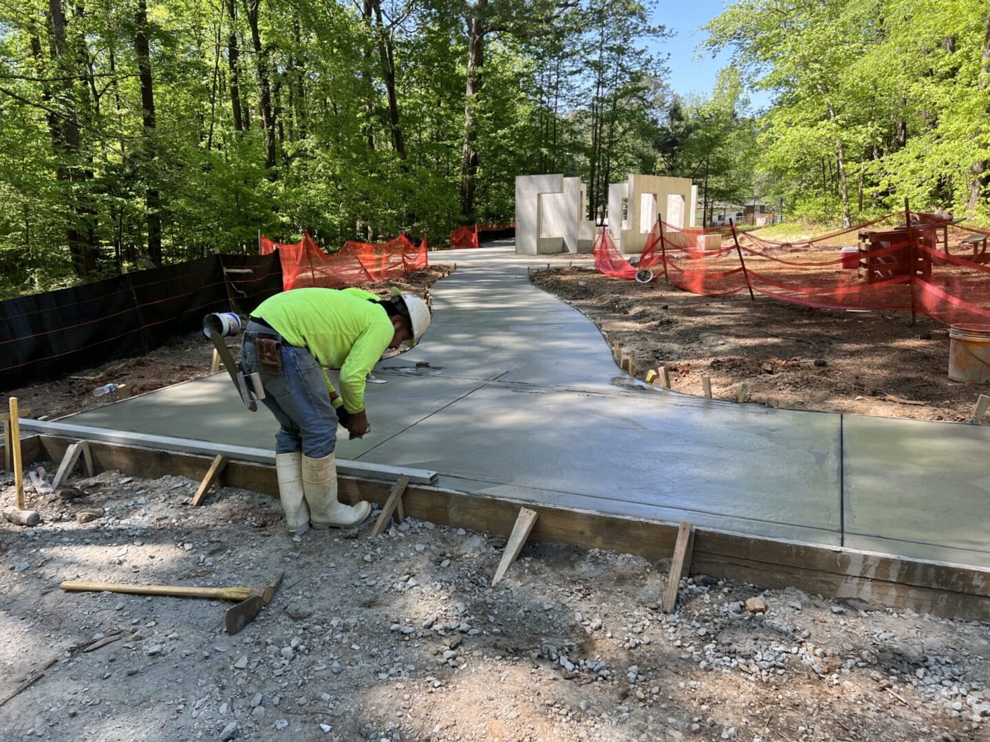 A man working on concrete in the dirt.