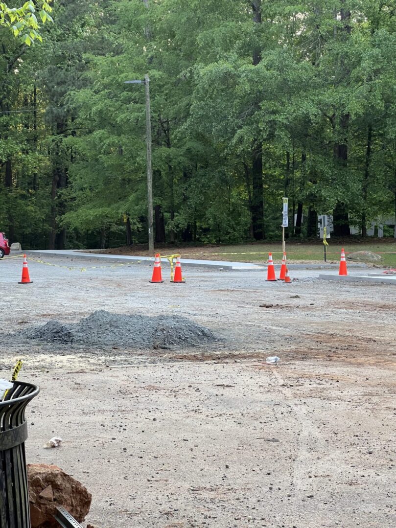 A group of orange cones sitting on top of a dirt field.