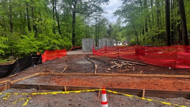 A construction site with trees and orange caution tape.