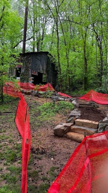 A red tarp covers the entrance to an abandoned cabin.