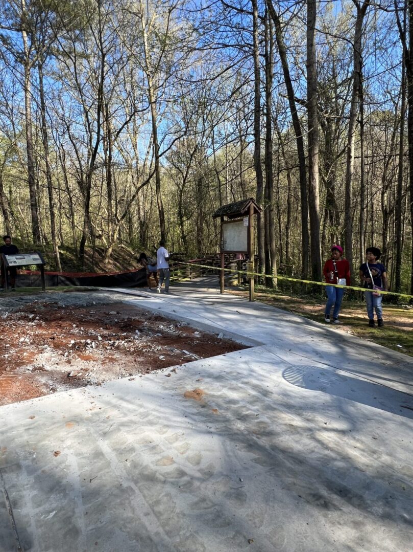 A group of people standing around in the woods.