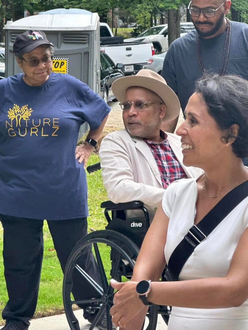 A woman in a wheel chair with two other people.