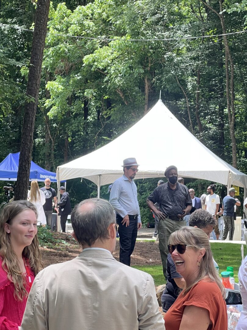 A group of people standing around under a tent.