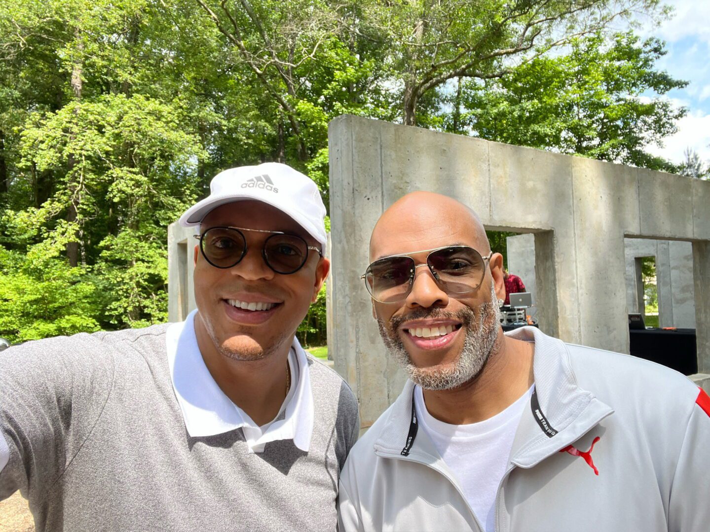 Two men posing for a picture in front of a wall.