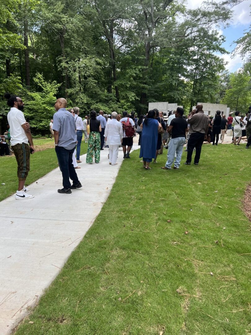 A group of people standing on the sidewalk.