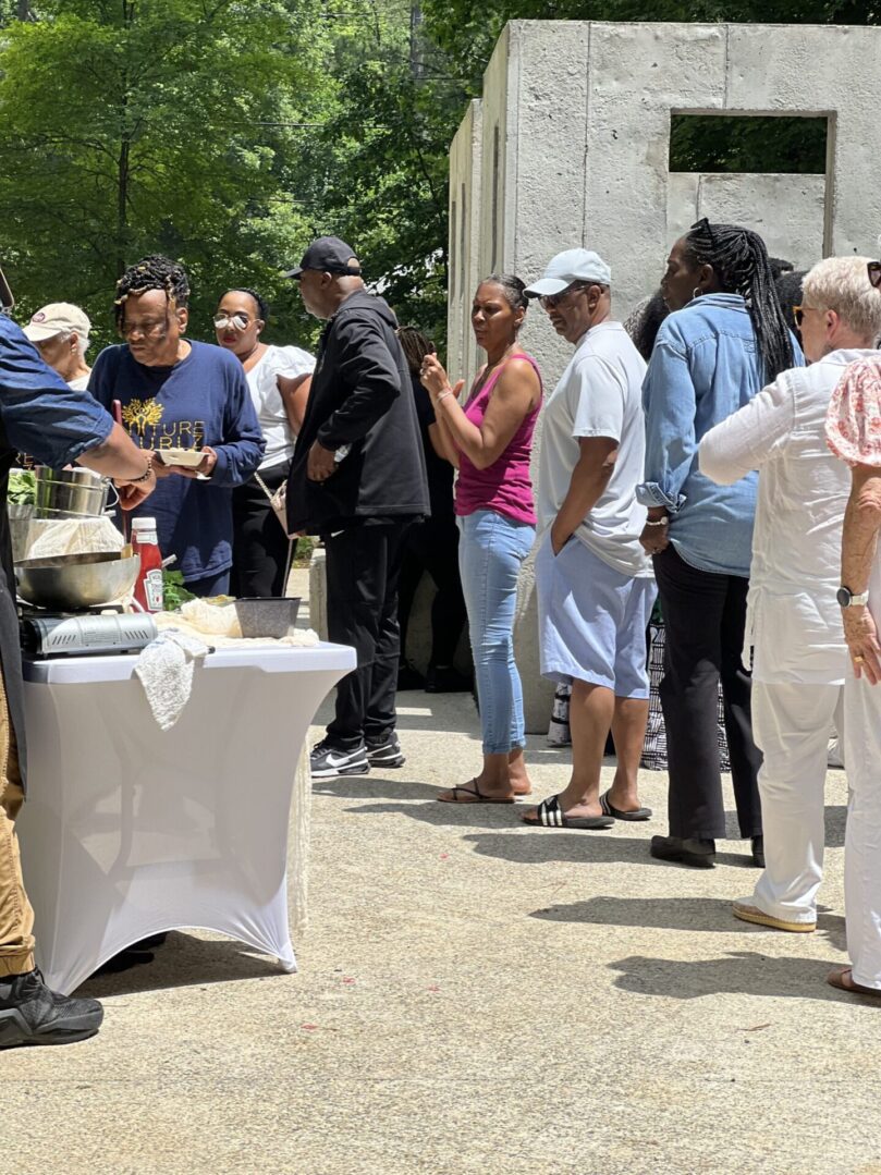 A group of people standing around a table.