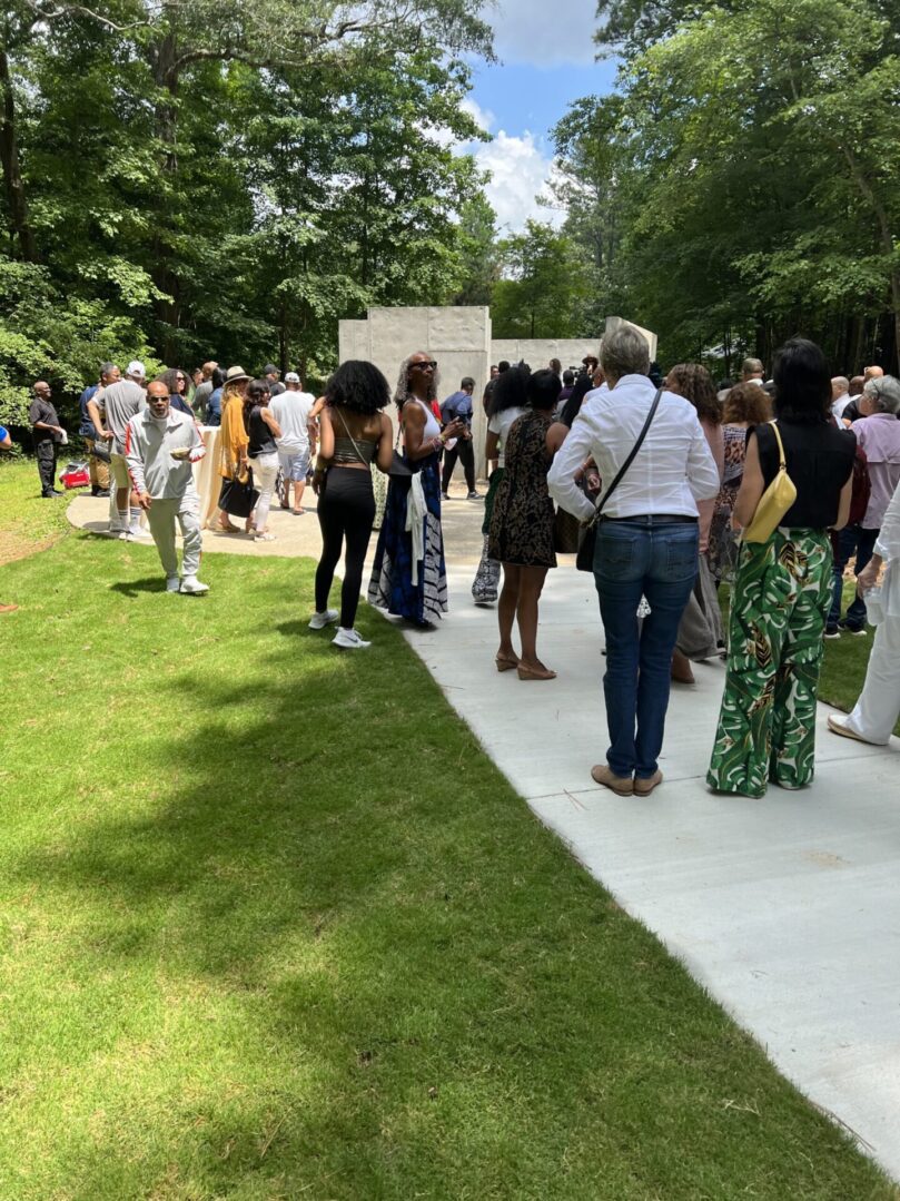 A group of people standing on the sidewalk.