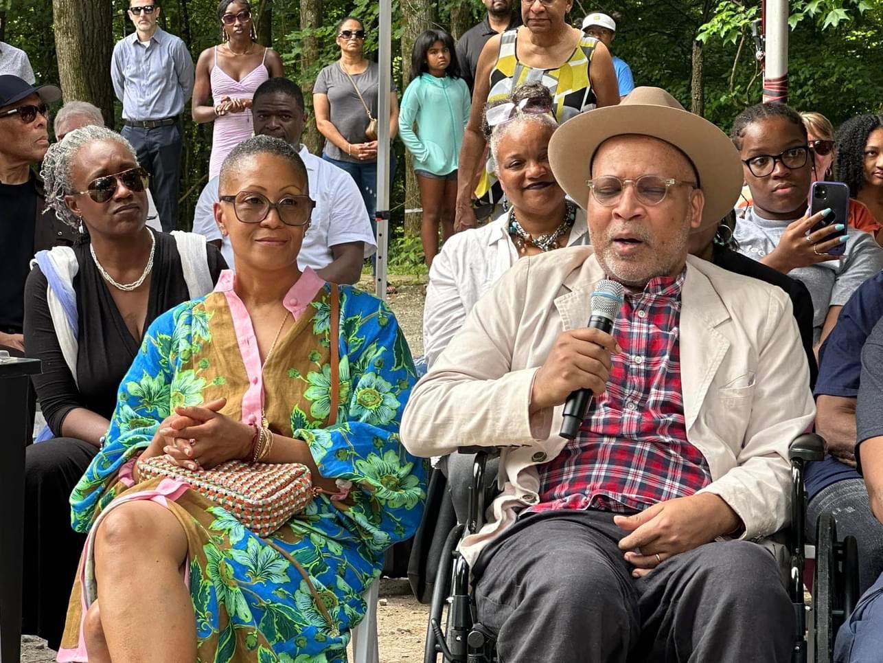 A group of people sitting on chairs in front of a crowd.