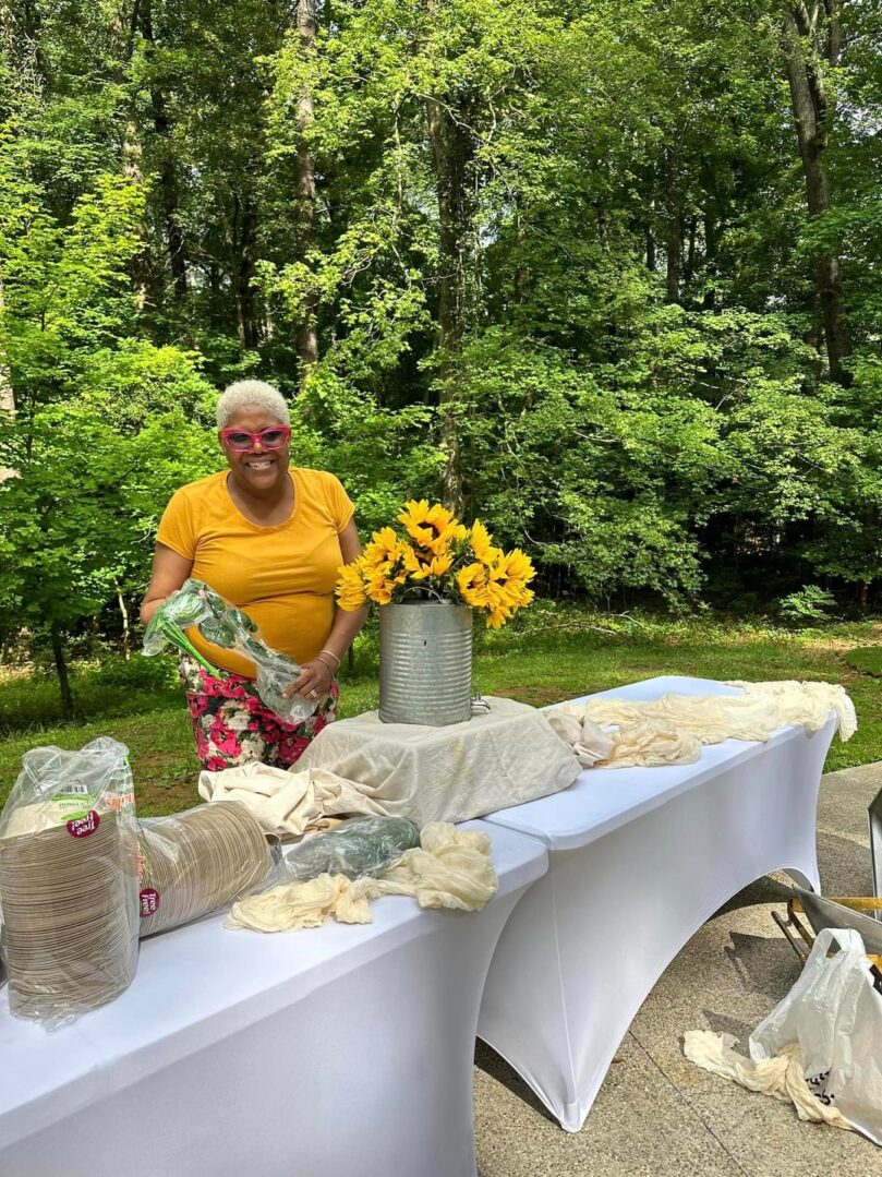 A woman standing next to a table with flowers.