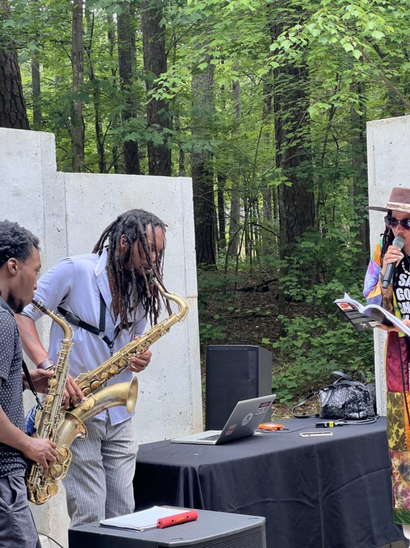 A group of people playing musical instruments in the woods.