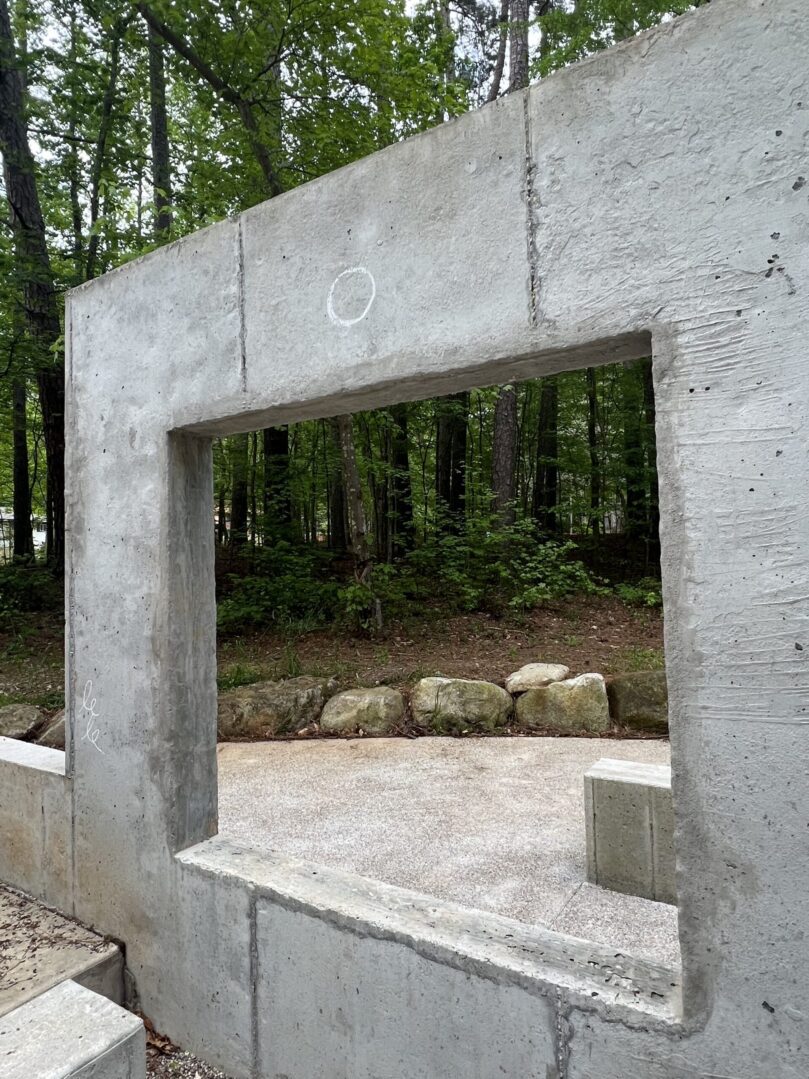 A concrete wall with a window in the middle of it.