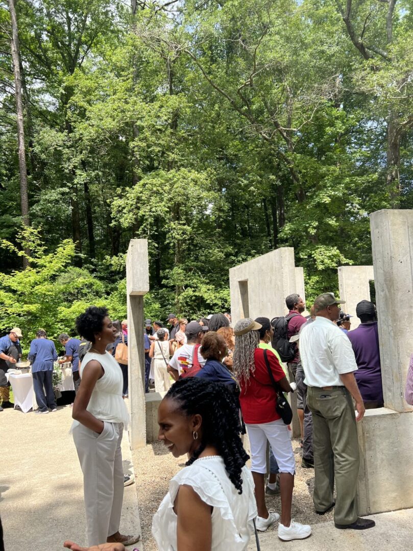 A group of people standing around in the woods.