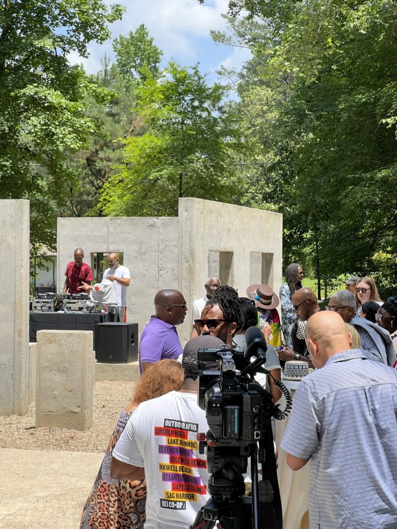 A group of people standing around in front of concrete walls.