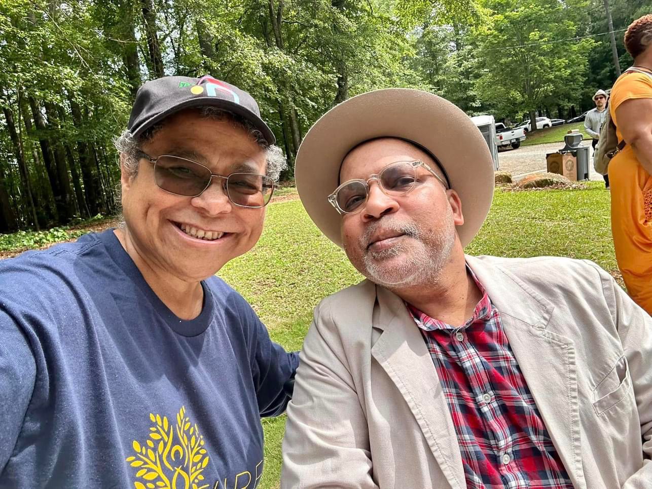 Two men posing for a picture in the park.