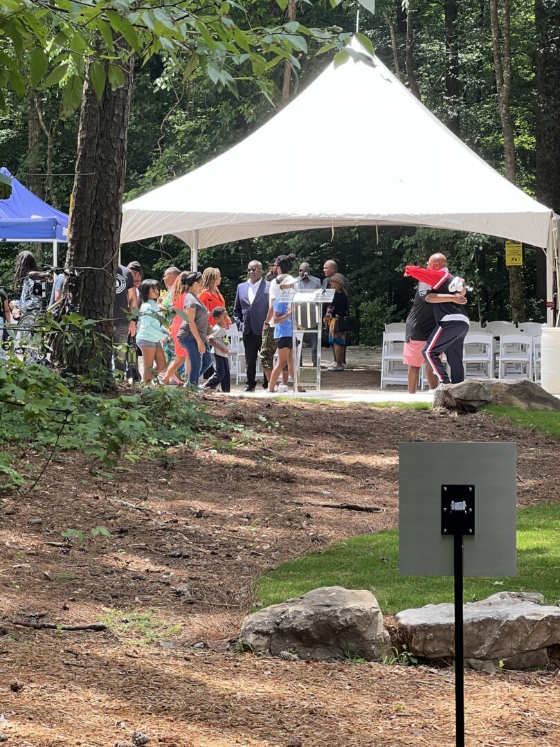 A group of people standing under a tent.