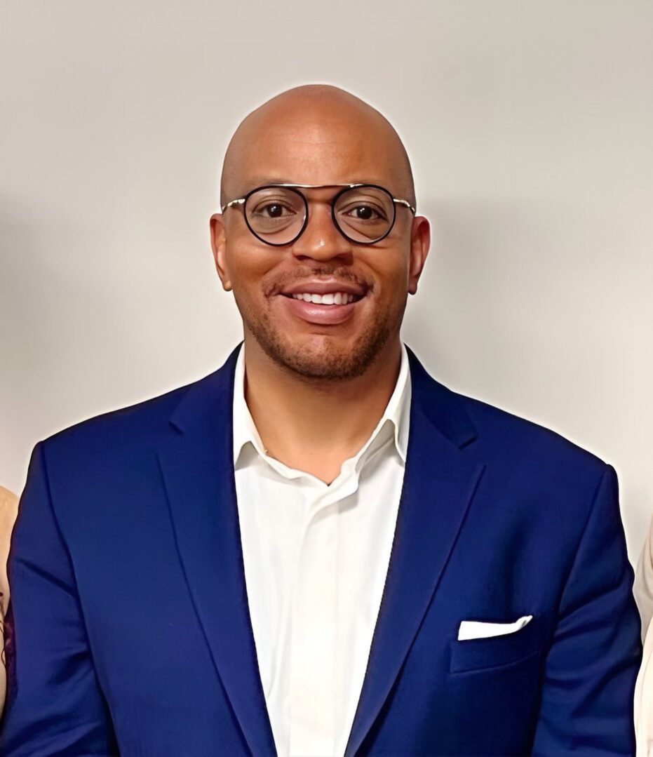 A man in a blue suit and glasses.