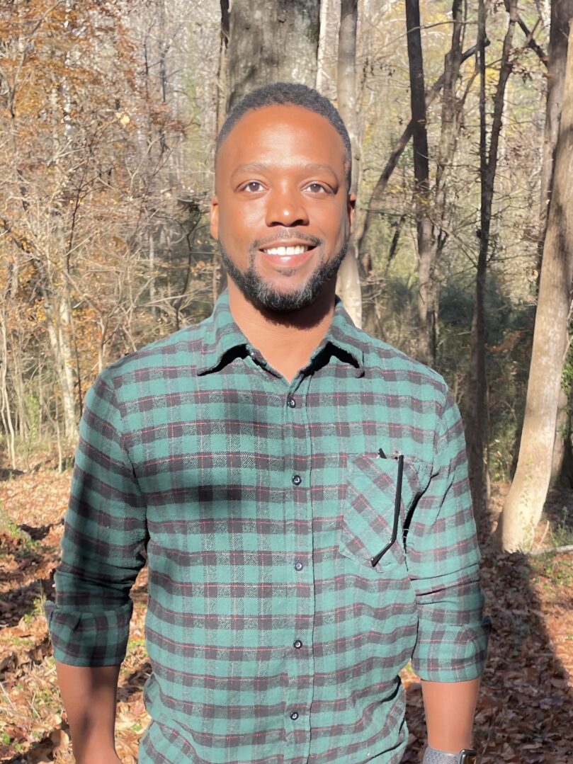 A man standing in front of some trees